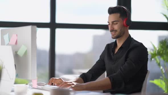 Side View Portrait of Handsome Young Man Typing on Computer Keyboard Sitting in Home Office Enjoying