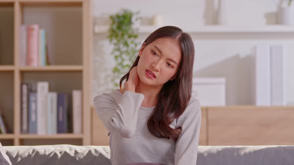 An Asian woman  do self massage at her neck and shoulders