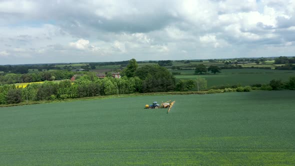 Aerial view of farming tractor crop sprayer in the countryside