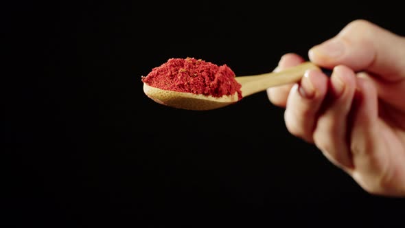 Pouring Paprika on Black Background Using Seasoning and Flavors