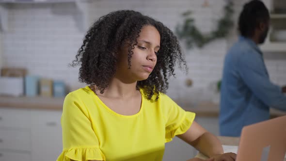 Portrait of Tired Beautiful Young African American Woman Rubbing Neck As Blurred Man Passing at