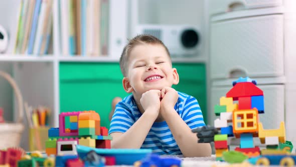 A Curious Boy is Playing with Colorful Plastic Building Kit and Having Fun