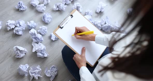 Woman Sitting on Floor Near Crumpled and Scattered Papers and Writing Business Plan Closeup Movie