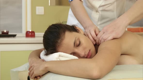 Young Woman Enjoying Shoulder Massage in a Spa