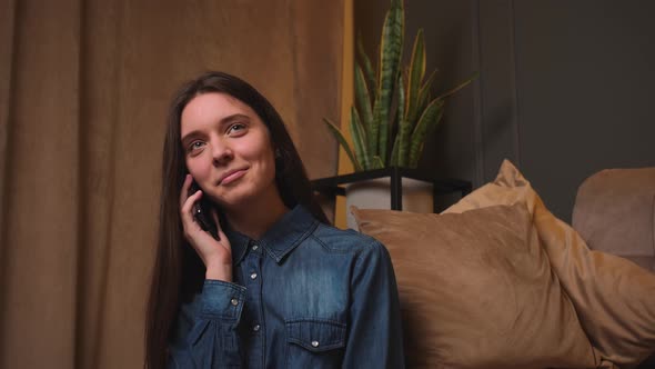 Smiling Woman Talking on Smartphone at Home Resting Communicating with Friends Learns Good News