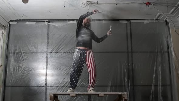 Fat Bearded Adult Man in Protective Helmet and USA Flag Print on Pants Remove Construction Whitewash