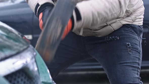 Angry Man Breaking Car with Big Hammer. Concept of Terror and Vandalism