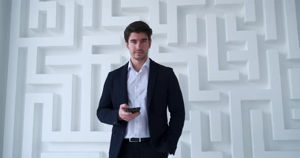 Portrait of Young Confident Business Man Using Smartphone in Modern Office