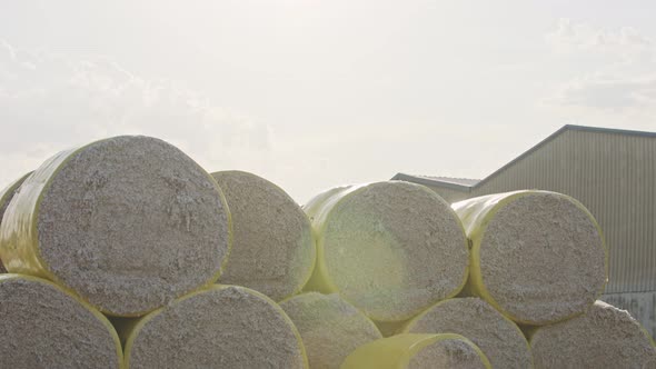 Large stacks of cotton bales at a cotton gin after harvest