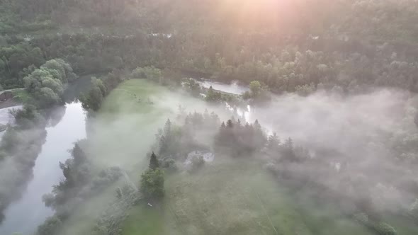 Flying over a river in mist on a beautiful sunrise