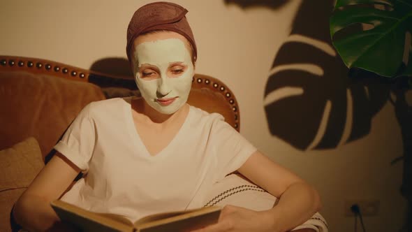 Woman at Home Reading Book with Face Skincare Mask at Evening Spbas