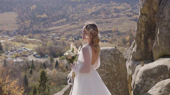 Pretty Young Bride Wearing Long White Dress Walking Against Mountains View