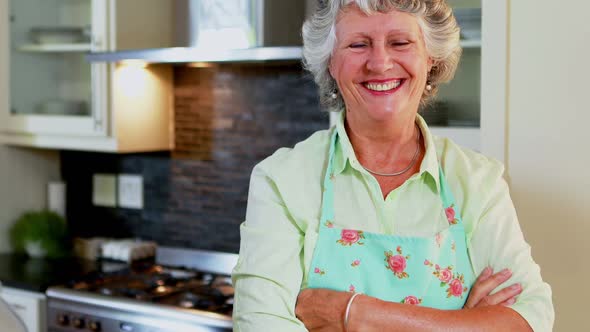 Senior woman standing with arms crossed in kitchen 4k