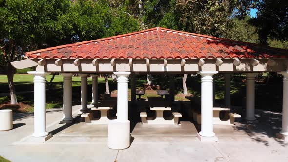 Aerial crane shot rising over a park gazebo.