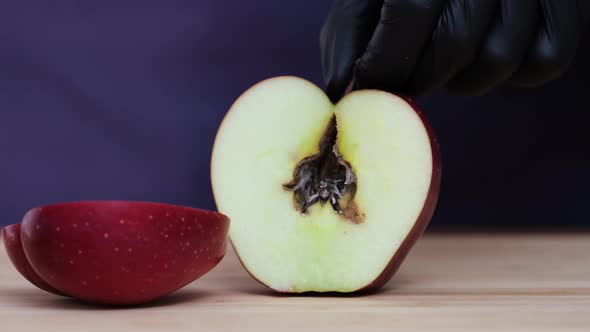 Half apple in plate, rotted from inside, the core is rotten