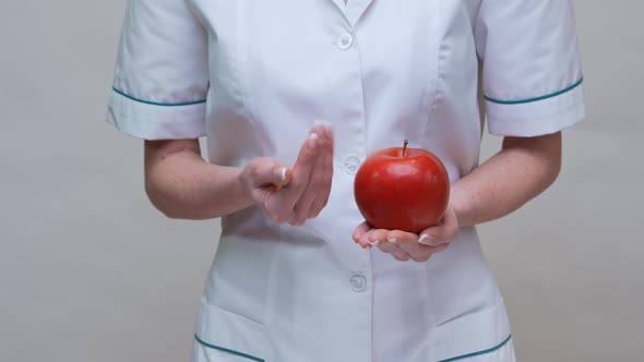 Nutritionist Doctor Healthy Lifestyle Concept - Holding Red Apple and Medicine or Vitamin Pill