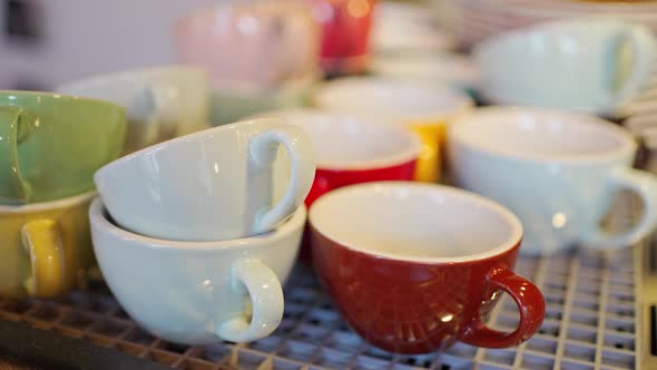 View of Colored Ceramic Mugs for Coffee Which Stand in a Special Place for Warming Up on a Coffee