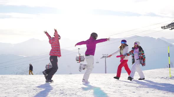Four Caucasian Females Running Towards Each Other and Hugging in Mountain Ski Resort in Slowmotion