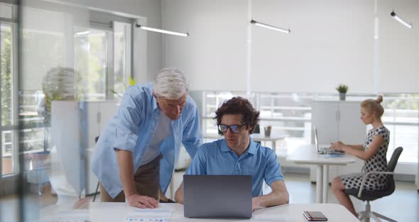 Male Colleagues Busy Working on Laptop at Office Meeting