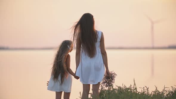 Mother and Daughter Strolling Near the Sea