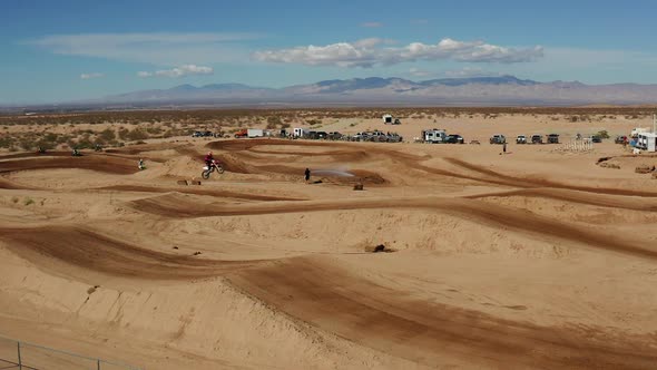 Motocross rider catching air on ramp in Mojave Desert, AERIAL SLOW MOTION