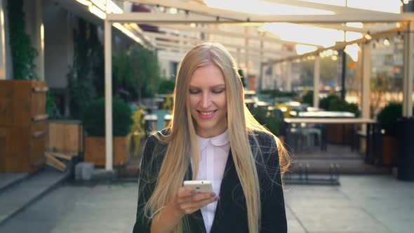 Formal Business Woman Walking on Street. Elegant Blond Young Woman in Suit and Walking on Street and