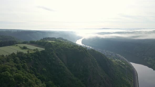 Steep sloping river valley on a sunny and misty morning near Cochem, Zell. Wide angle fly over drone