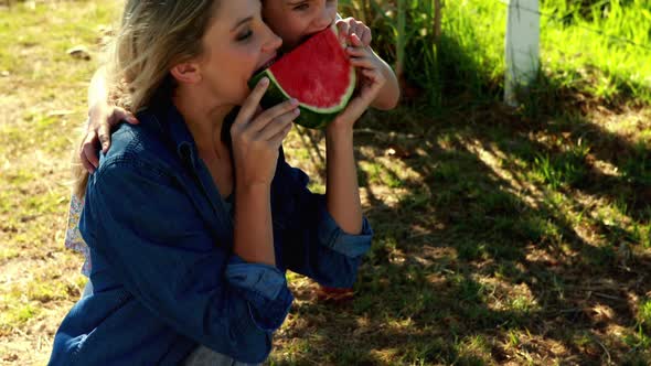 Mother and daughter having watermelon in park 4k