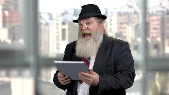 Portrait of an Old Man in Suit with Tablet Pc Laughing Out Loud