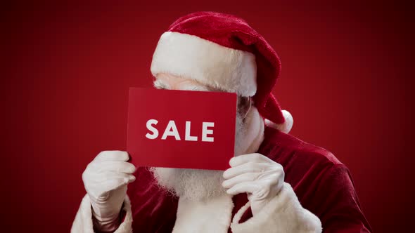 Portrait of Joyful Santa Holding Sale Lettering in Hands