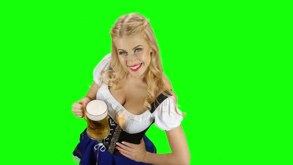 Bavarian Girl in Bavarian Costume Holding a Glass of Beer and Laughs. Green Screen