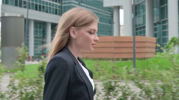 Close Up of Young Businesswoman Walking on the Street Side Pose