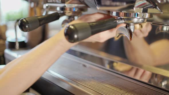 a Barista's Hand Cleans the Surface of a Professional Coffee Machine in Which Two Double Holders are