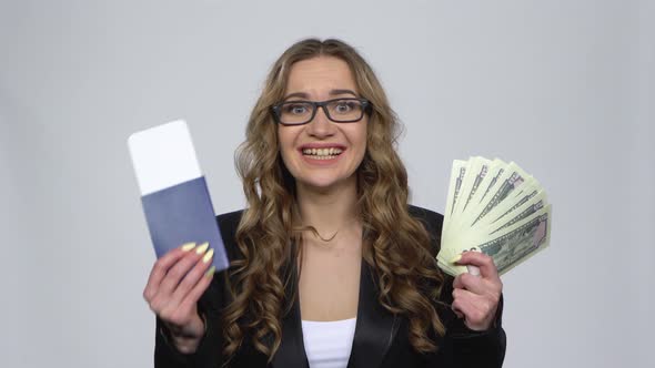 Girl Is Holding Passport, Plane Ticket and Money Very Rejoicing and Enjoying on Gray Background