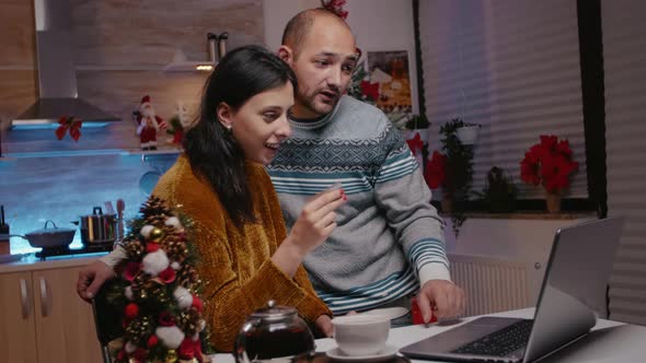 Festive Couple Using Credit Card for Christmas Shopping