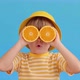 Surprised child holding halves of orange fruit like a sunglasses - VideoHive Item for Sale