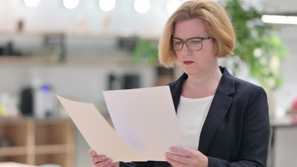 Portrait of Old Businesswoman Having Loss on Papers in Office 