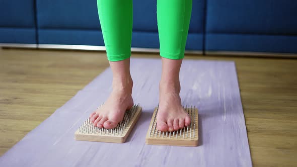 Close Up of Woman's Feet Standing on Sadhu Board Indoors at Home