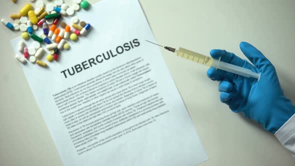 Tuberculosis Word on Conclusion, Hand With Syringe, Pills and Tablets on Table