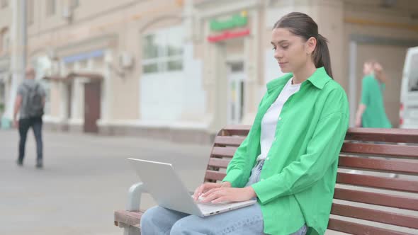 Hispanic Woman Leaving Bench After Closing Laptop