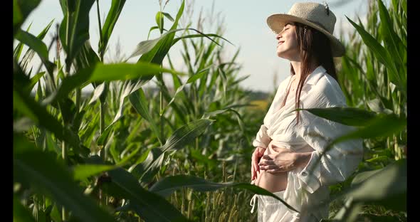 Pregnant Woman in a White Costume in a Green Field