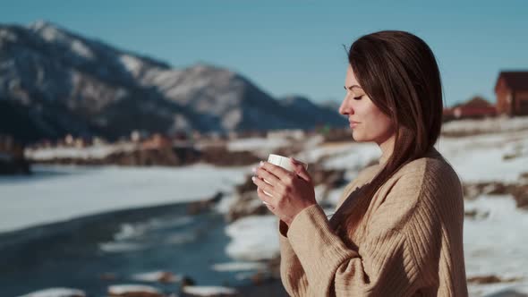 Woman Drinking Coffee While Standing Outside on a Frosty Morning