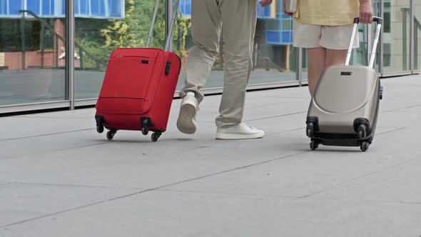 Couple with Suitcases Walking Through the Airport or Train Station