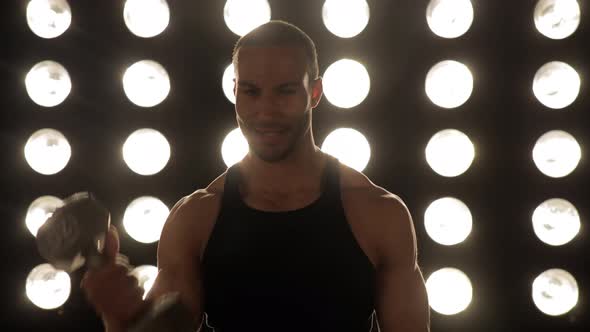 Athletic man workouts out in front of a wall of lights