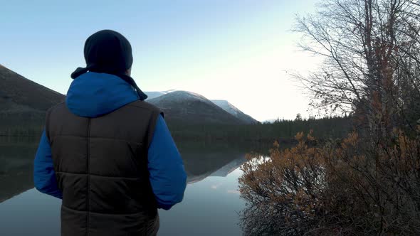 A Man, a Middle-aged Athlete, Meets the Dawn in the Mountains. He Raises His Hands Up