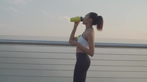 African Female with Energy Drink Resting After Jog