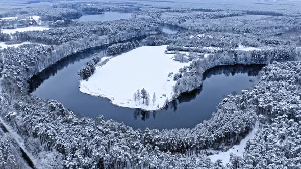 Curvy river and frozen forest. Aerial view of nature, Poland.