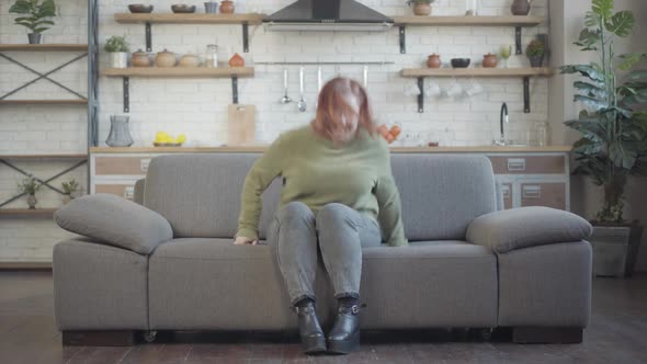 Joyful Redhead Plussize Woman Entering Room Inviting Friends and Smiling