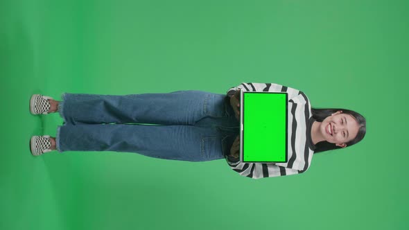Full Body Woman Holding Green Screen Computer While Standing On Green Screen