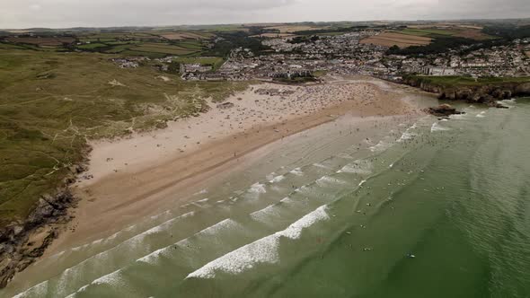 Perranporth Beach And Sea Full Of Summer Surfers and Swimmers Aerial View